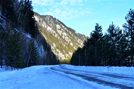 winter road along the river and mountains photo
