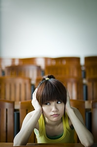 A Beautiful Chinese Girl Sitting Tired At A Desk photo