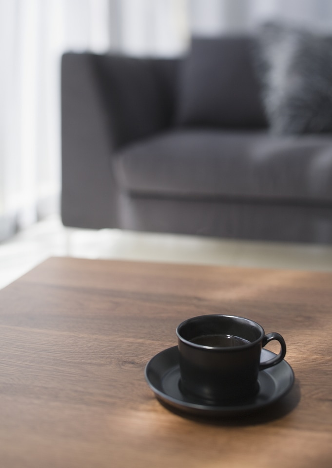 Black cup of coffee on table in living room
