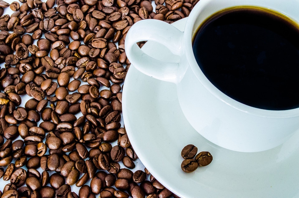 Cup of black coffee and coffee beans