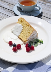 Victoria sponge cake with cream, served with raspberries and tea photo