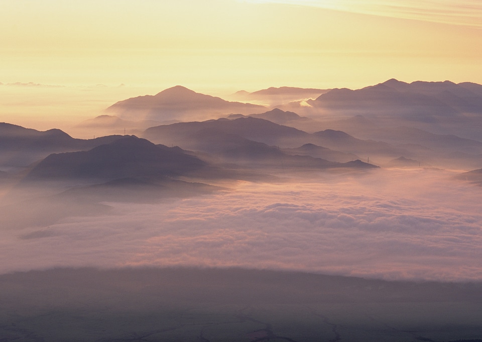 Picturesque mountain valley filled with curly clouds at sunrise