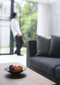 Fresh fruits on table in living room with a man
