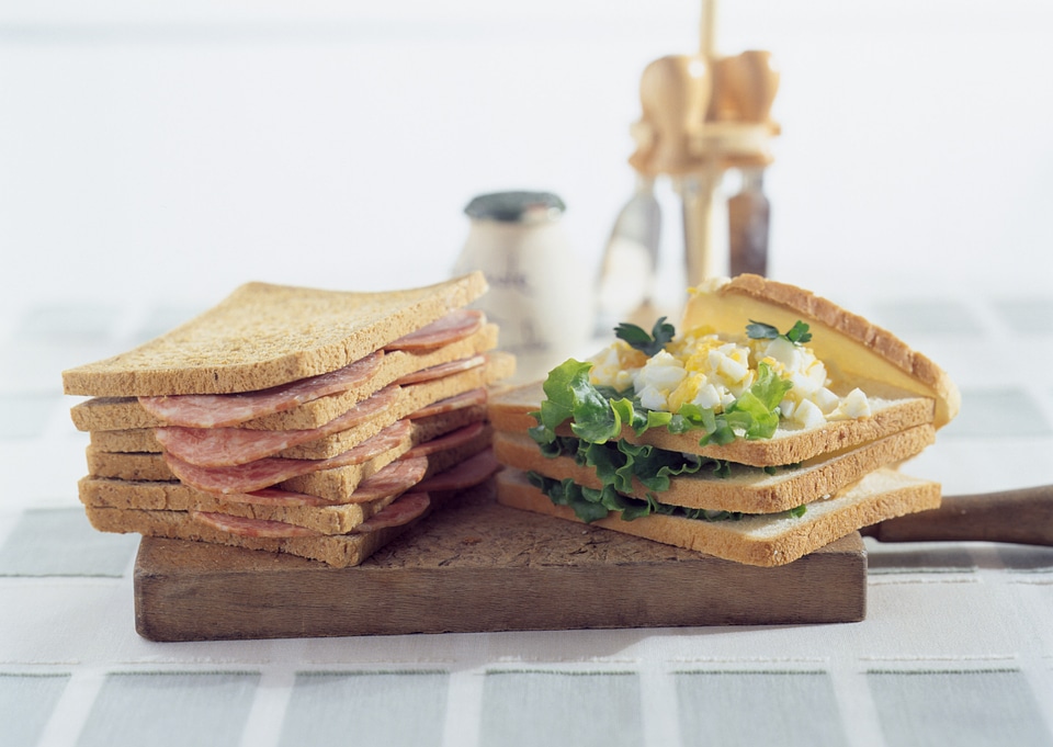 Freshly made clubsandwiches served on a wooden chopping board