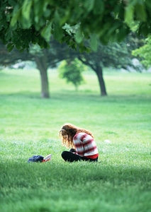 Cute Little Girl Reading Book Outside on Grass photo