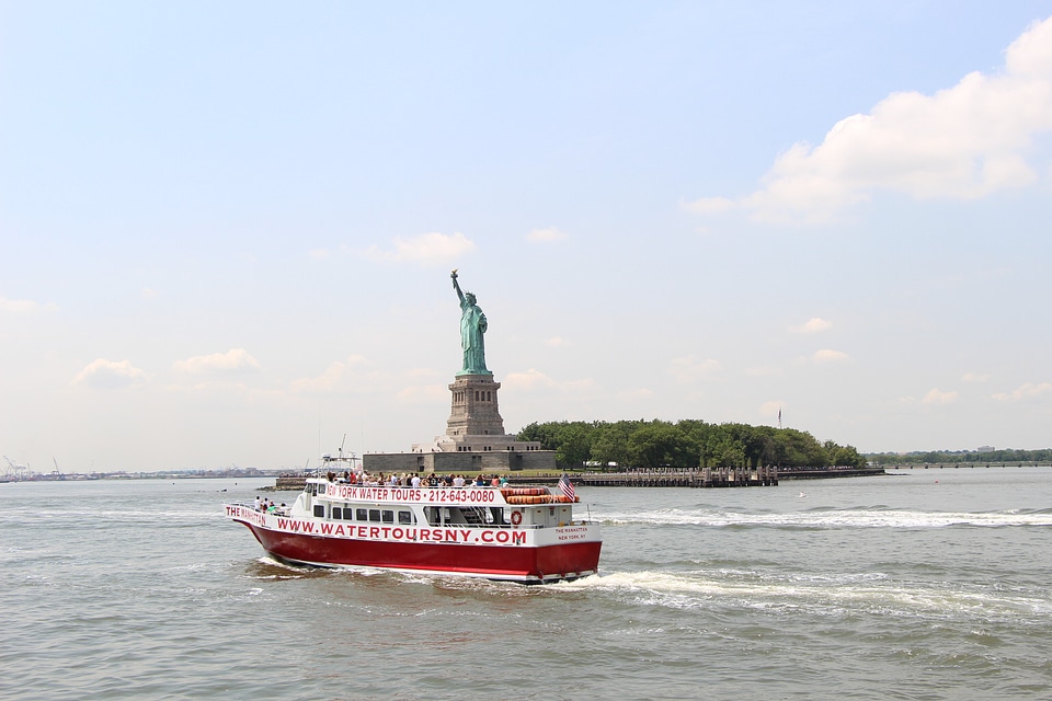 The Statue of Liberty and a passenger boat in front
