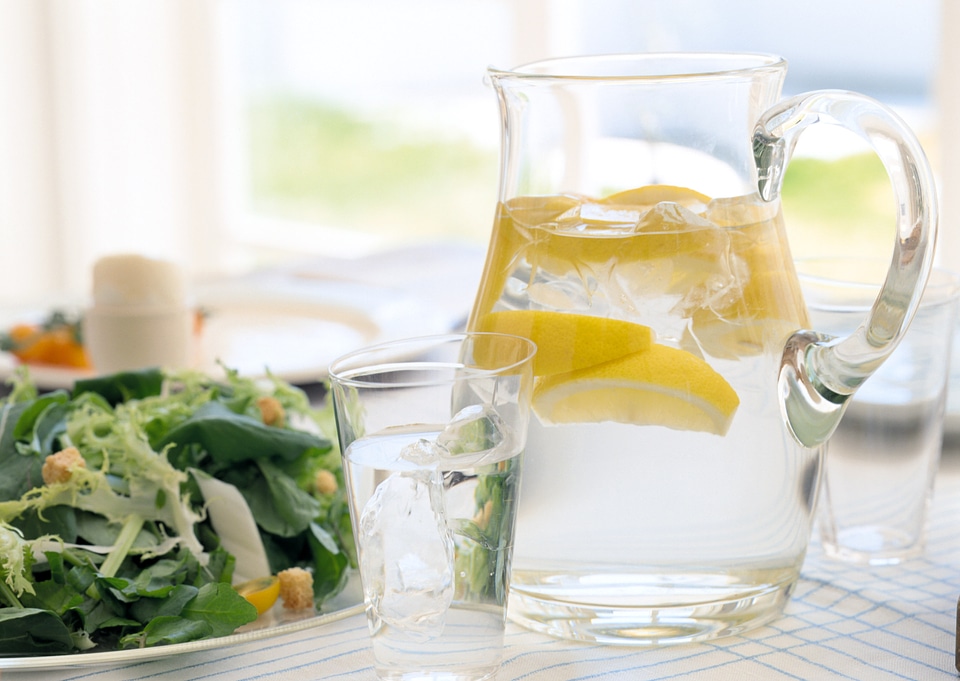 Salad and water jug on table