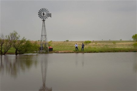 stockpond with windmill and rancher with NRCS photo