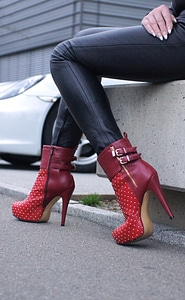 Woman wearing black leather pants and red high heel shoes photo