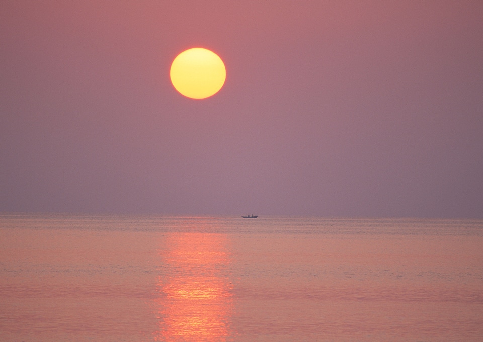 Beautiful sunset on a tropical beach with a boat