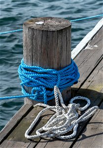 Mooring bollard with blue rope photo