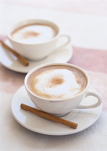 Two cups of cappuccino with cinnamon stick