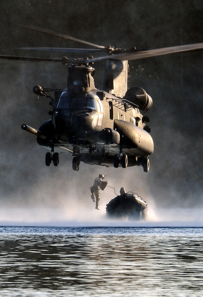 An Airman jumps out of an MH-47 Chinook helicopter