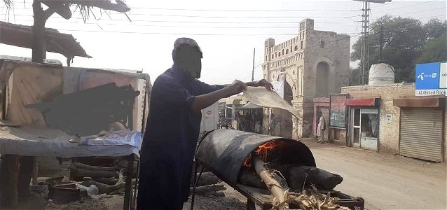 A man baking local bread PASTI (Manay) near Muddy Gate Kulachi Dera Ismail Khan  Khyber Pakhtunkhwa Pakistan