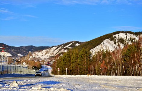 winter road along the river and mountains photo