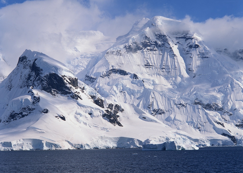 Vibrant blue icebergs in front of snowy mountains