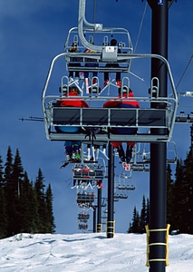 Skiers and snowboarders on a ski lift photo