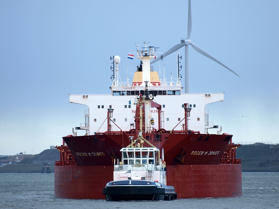 Tugboat assisting cargo ship to harbor