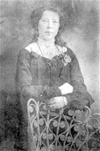 Studio portrait of a lady standing behind a chair [n.d.]