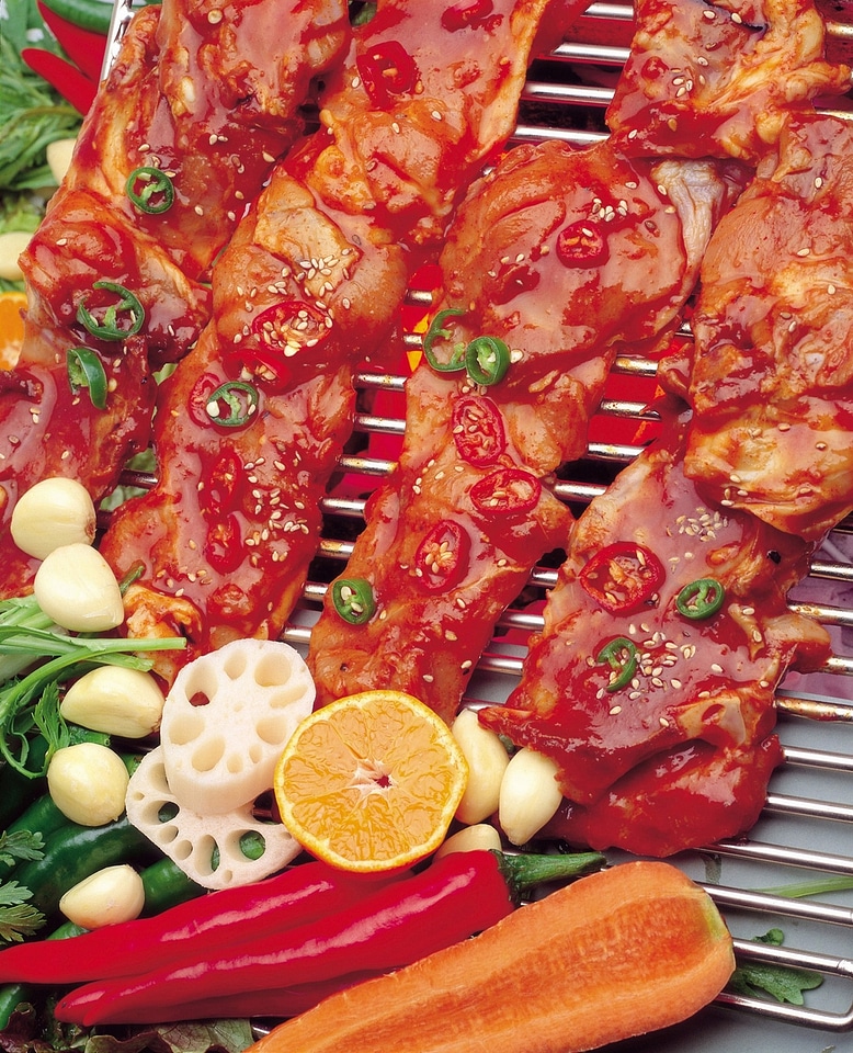 Korean dish bulgogi setup iwth meat, vegetables and grill