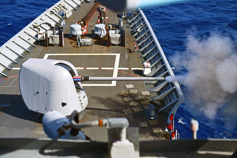 The guided-missile cruiser fires gun photo
