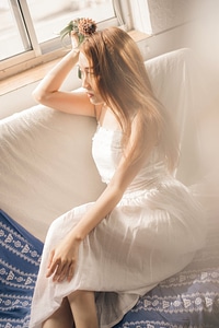 beautiful young girl sitting by the window summer day photo