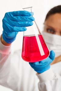 Scientist holding an Erlenmeyer flask with pink liquid photo