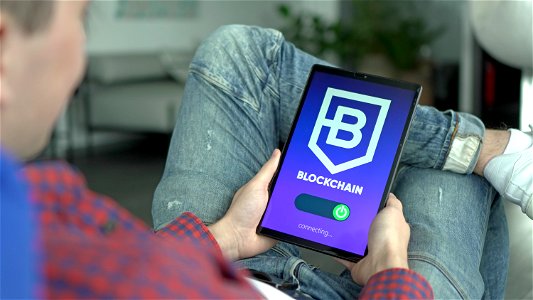 Man connects to a blockchain platform using a tablet photo