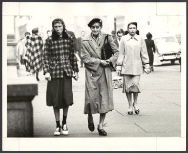 Two women, full-length portrait, walking on sidewalk in Fifth Avenue, in NYC