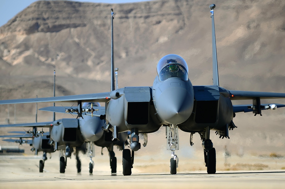 A group of F-15E Strike Eagles taxi following a training combat m