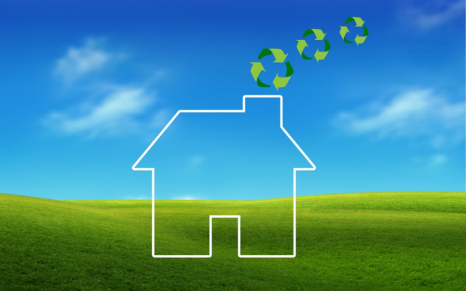 Protecting gesture around a house icon with green recycling symbo