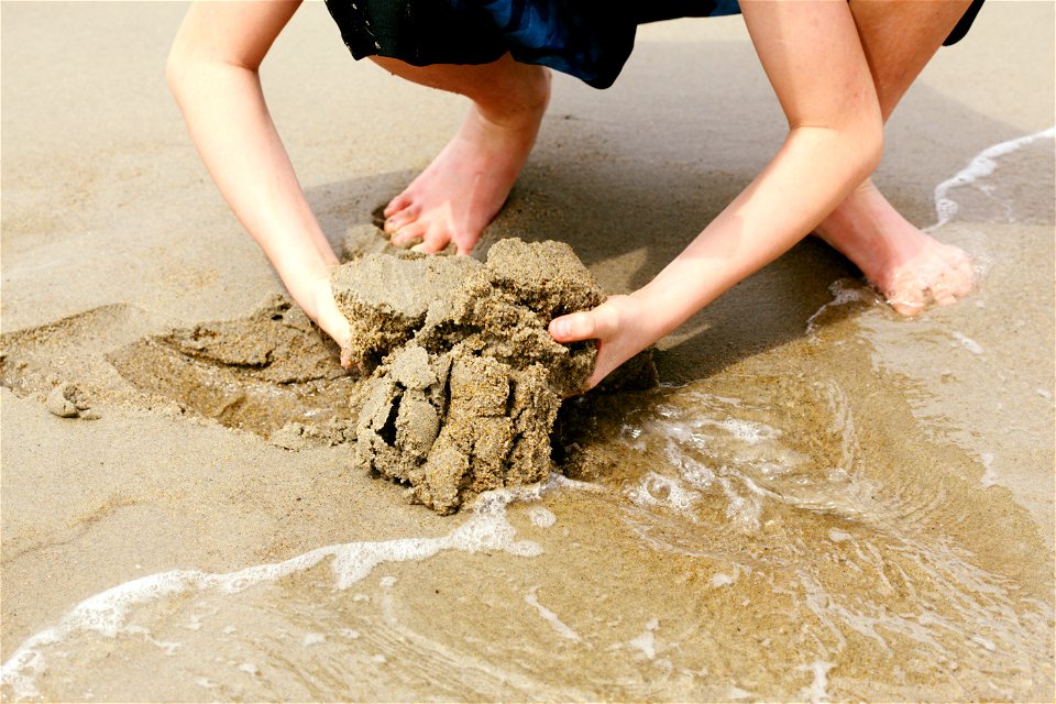 Child Digging in Wet Sand photo