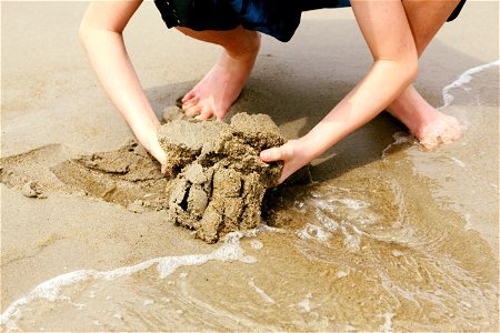Child Digging in Wet Sand