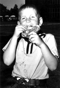 Youngster eating chicken, unidentified