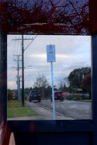 Inside bus shelter looking at bus stop sign and street, Ngāmotu New Plymouth, Taranaki, New Zealand photo