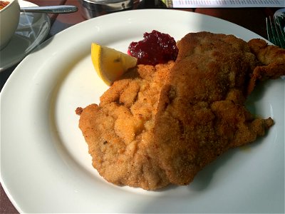 Schnitzel with fried potatoes, lemon and a dip raspberry photo
