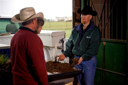 Soil Scientist Nathan Haile visits with ranchers about soil health in soil samples taken in the pasture.