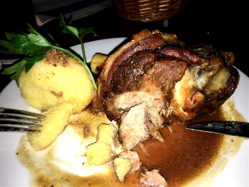 Bavarian knuckle with dumpling in a traditional restaurant in Munich.