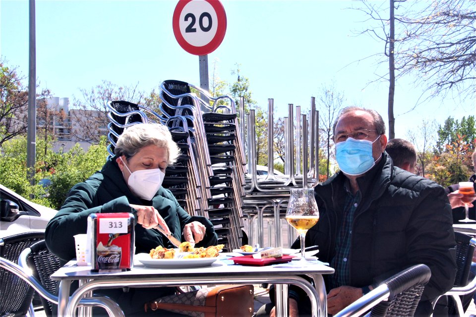 Plano medio de una pareja en una terraza de un bar