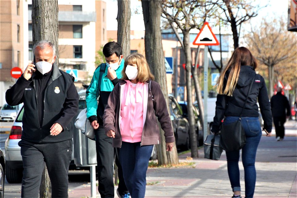 Tres personas paseando con mascarilla y en ropa de deporte photo