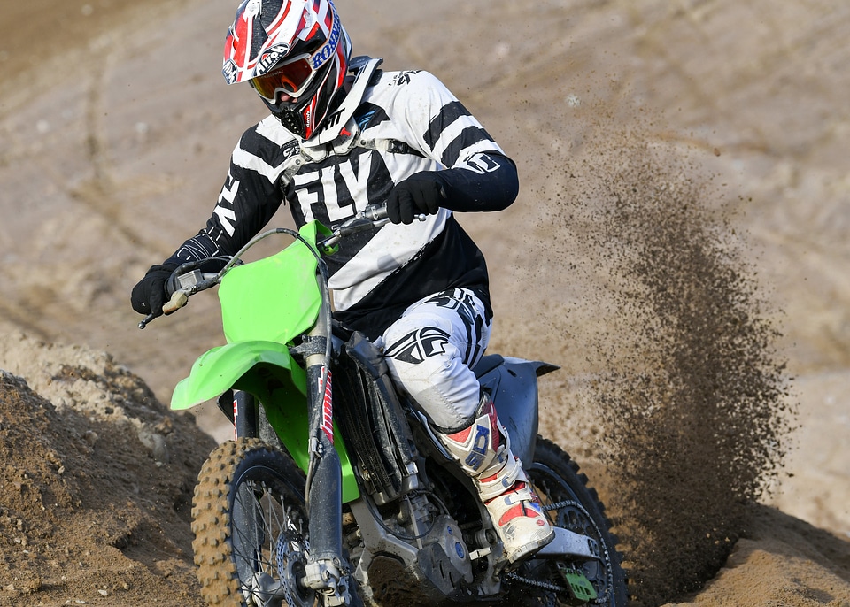 Motocross rider accelerating in curve in dirt track