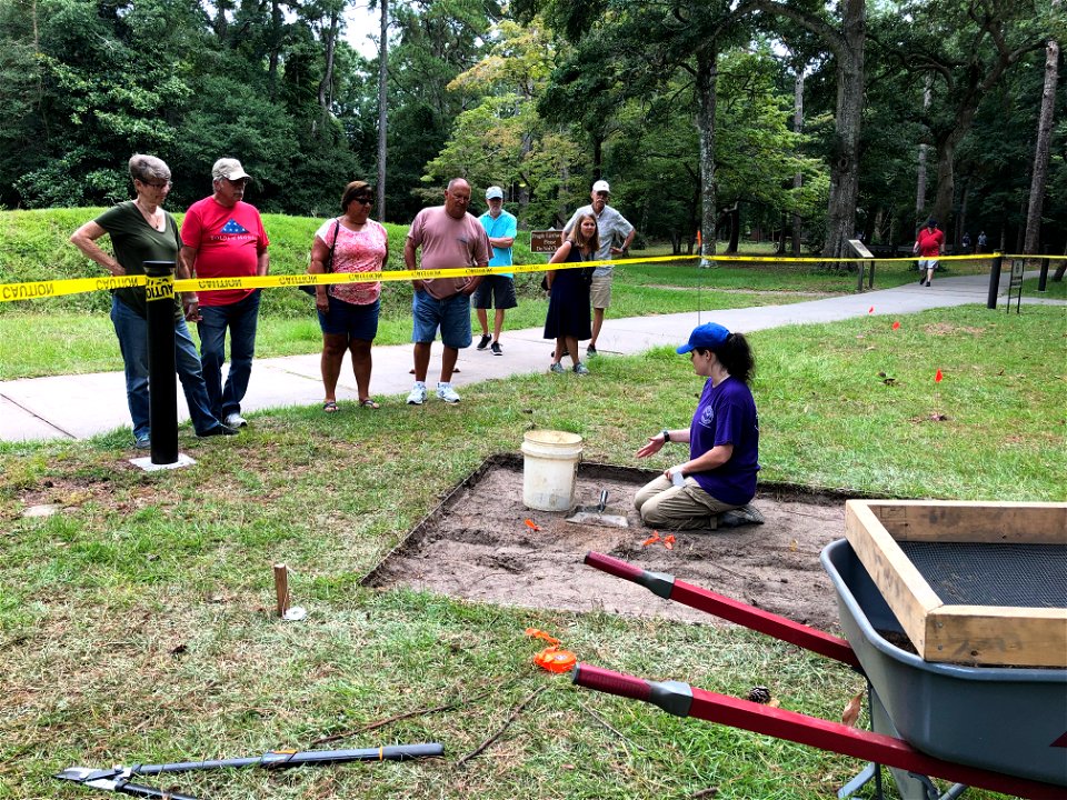 Archaeology volunteer Rachel Boyd speaks with Fort Raleigh visitors about excavation techniques and describes finds at Science Workshop site