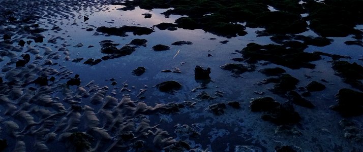 Sea water puddle on sand before dawn photo