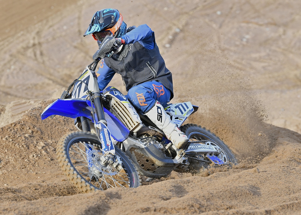 Motocross rider accelerating in curve in dirt track