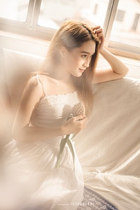 beautiful young girl sitting by the window summer day