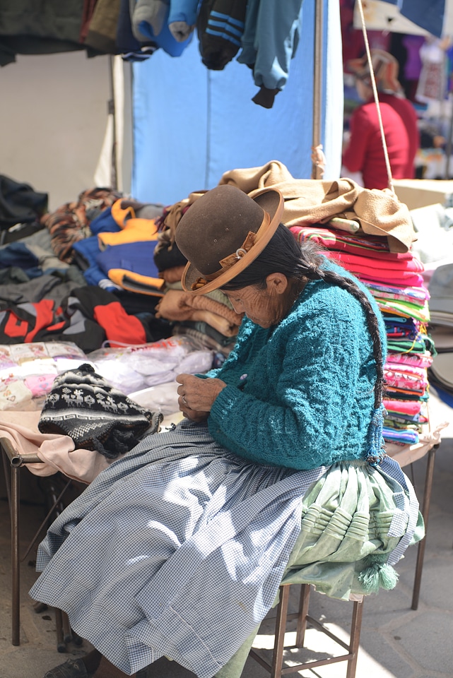 Bolivian woman in traditional costume knitting
