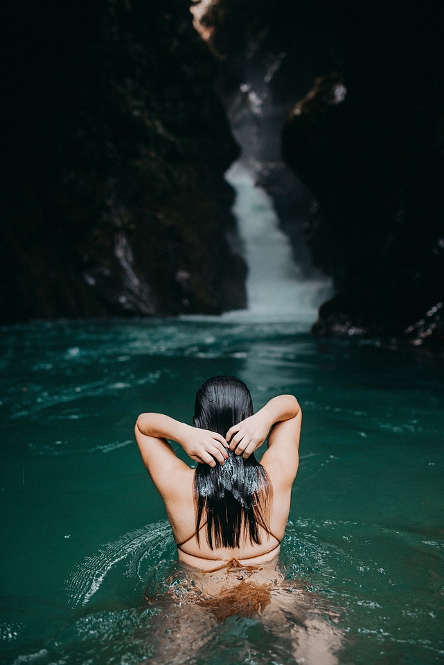 A girl swims in a natural pool