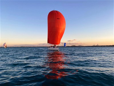 Red spinnaker yacht on sea photo
