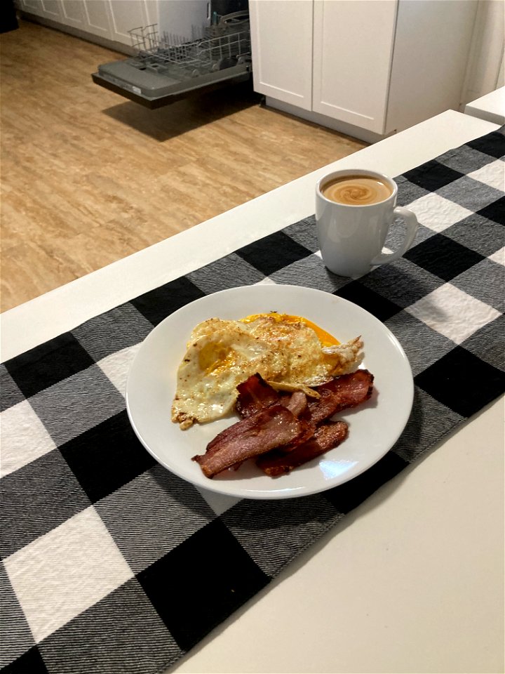 A breakfast of eggs, bacon, and tea photo