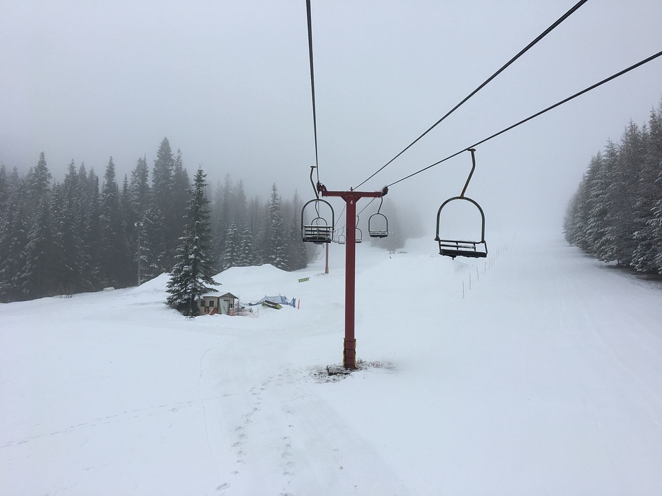 Ski lift with seats going over the mountain and paths